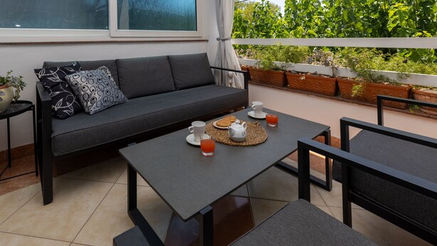 A modern outdoor seating area with a sofa, a table, and chairs.