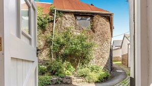 A narrow cobblestone alley with a stone building featuring a partially collapsed upper structure. - 2 bedroom accommodation in Umberleigh (Umberleigh)