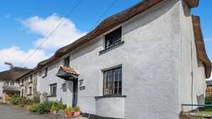 A white building with a thatched roof, a sign reading "Fish & Chips," and potted plants at the entrance. - 2 bedroom accommodation in Umberleigh (Umberleigh)