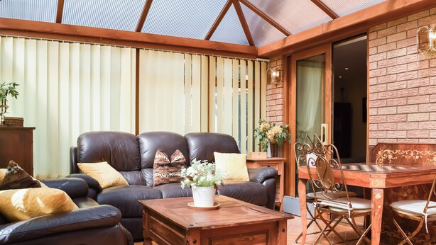 A cozy living area with a leather sofa, wooden coffee table, and a dining table with chairs. - 5 bedroom accommodation in Gamston, near Nottingham (Gamston, near Nottingham)