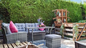 An outdoor seating area with a wicker sofa, a small table, and a fire pit. - 5 bedroom accommodation in Gamston, near Nottingham (Gamston, near Nottingham)