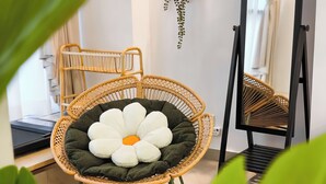 A wicker chair with a large flower-shaped cushion, a treadmill, and a mirror on the wall. - Kuchai Sentral by Manhattan Group (Kuala Lumpur)