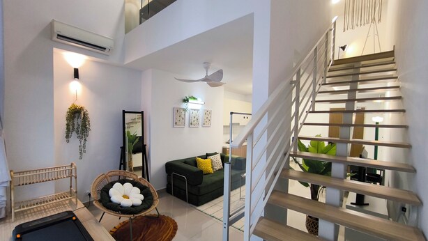 A modern living room with a staircase, a large mirror, and a green sofa. - Kuchai Sentral by Manhattan Group (Kuala Lumpur)
