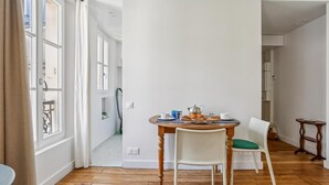 Uma sala de jantar com mesa de madeira, cadeiras e mesa posta para o café da manhã.