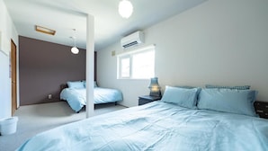 Una camera da letto con un letto grande, un comodino con una lampada, una finestra con persiane e un condizionatore d'aria.