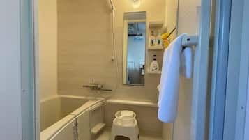 Une salle de bain avec une baignoire, des toilettes, une douche et un miroir.