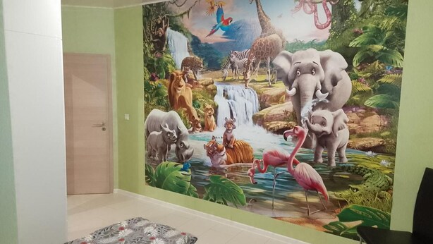 A room with a mural of jungle animals, a bed with patterned bedding, and a chair. - Fürstenhaus and Hofgeismar Center! (Hofgeismar)