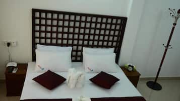 A hotel room with a large bed, two bedside tables, a telephone, and a coat stand.