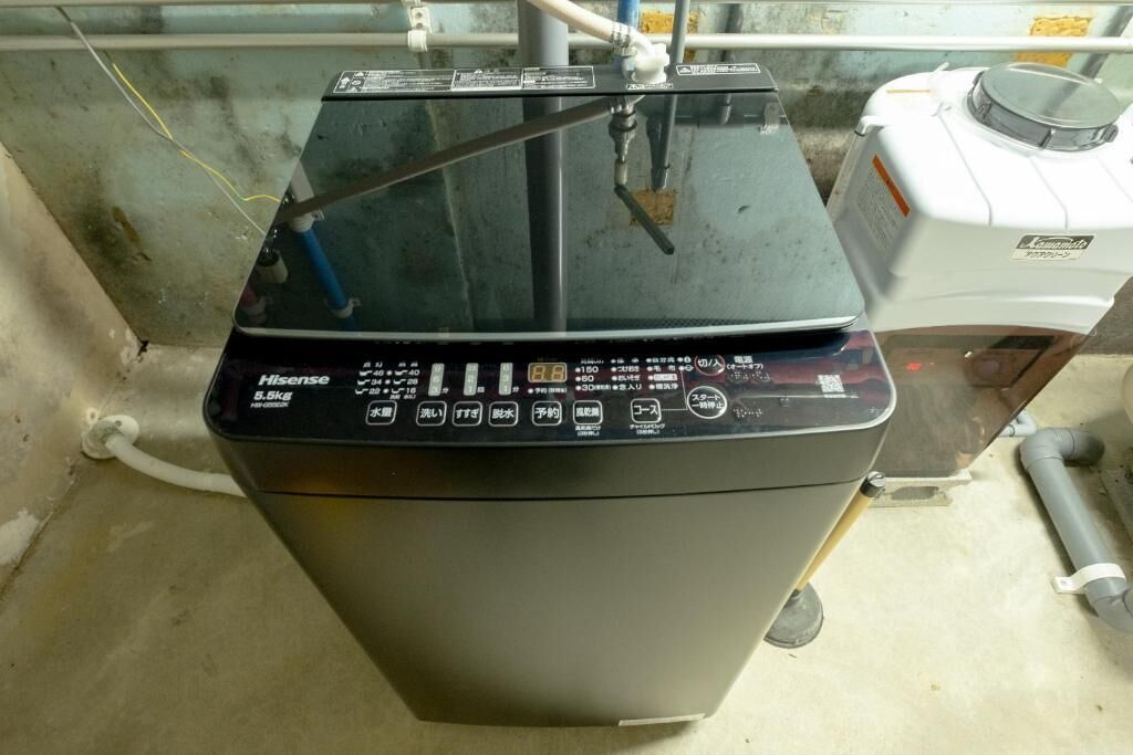 A compact, black Hisense washing machine with a control panel featuring multiple buttons and a digital display.