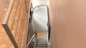 A metal stairway with a handrail, leading to a landing with a white door. - HB Apartment Kim Ma (Hanoi)