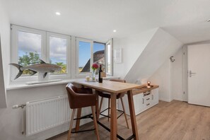 Eine moderne Küche mit Essbereich, großen Fenstern und Blick ins Freie.