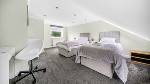 Une chambre moderne avec deux lits, un bureau et une chaise.