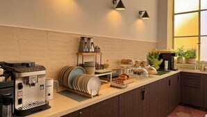 Una cucina moderna con angolo caffè, buffet e illuminazione a parete.