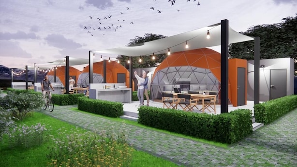 Een moderne eethoek buiten met hexagonale tenten en een geplaveid pad.