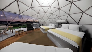 Een modern, geometrisch ingericht interieur met twee bedden, een zithoekje en uitzicht op het landschap.