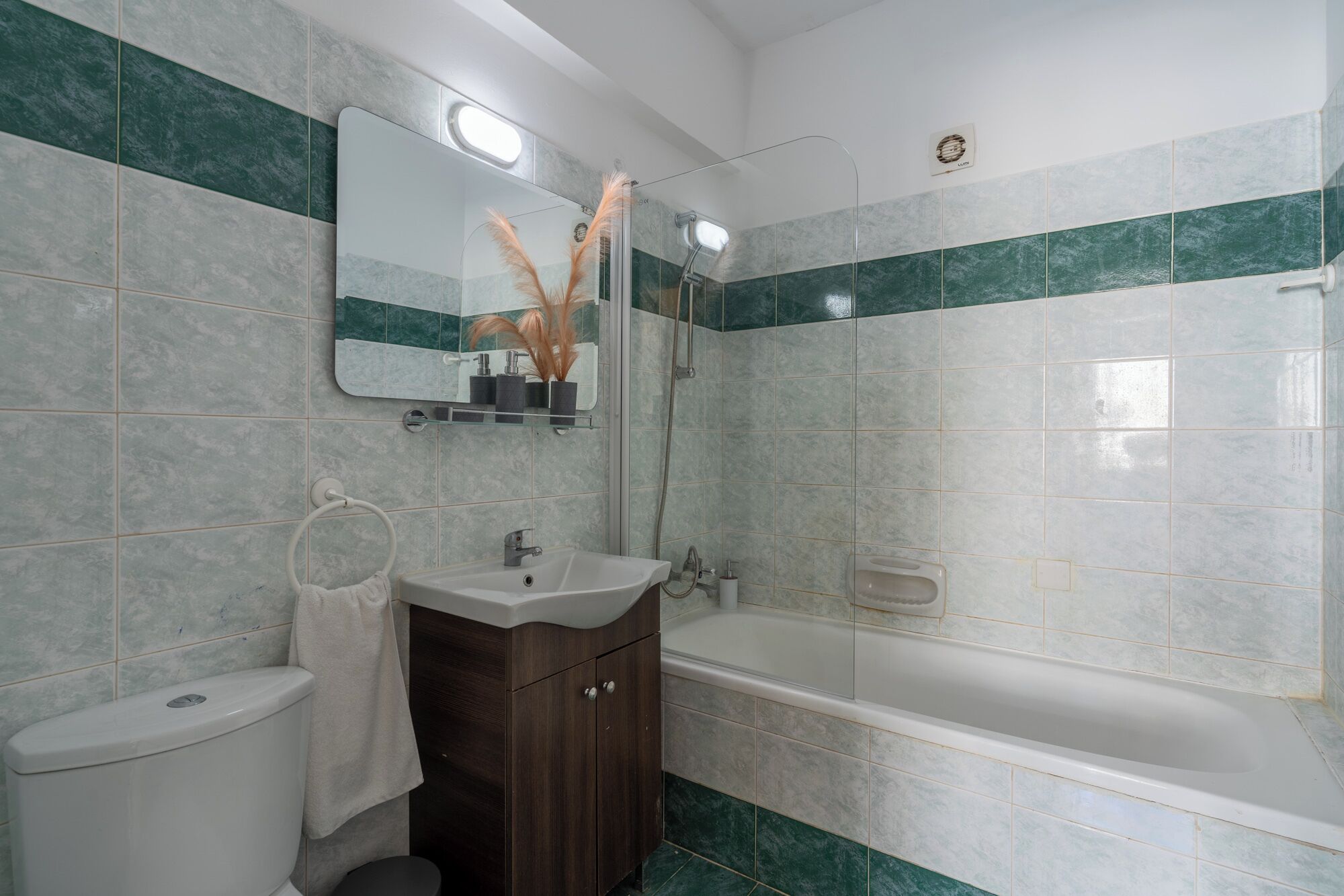 Ein Badezimmer mit Toilette, Waschbecken, Waschtisch und Badewanne.