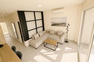 Una sala de estar moderna con un sofá seccional, una mesa de centro y una lámpara de pie.