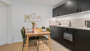 Een moderne keuken met donkere kastjes, een inbouwoven en een aanrecht met een spoelbak.