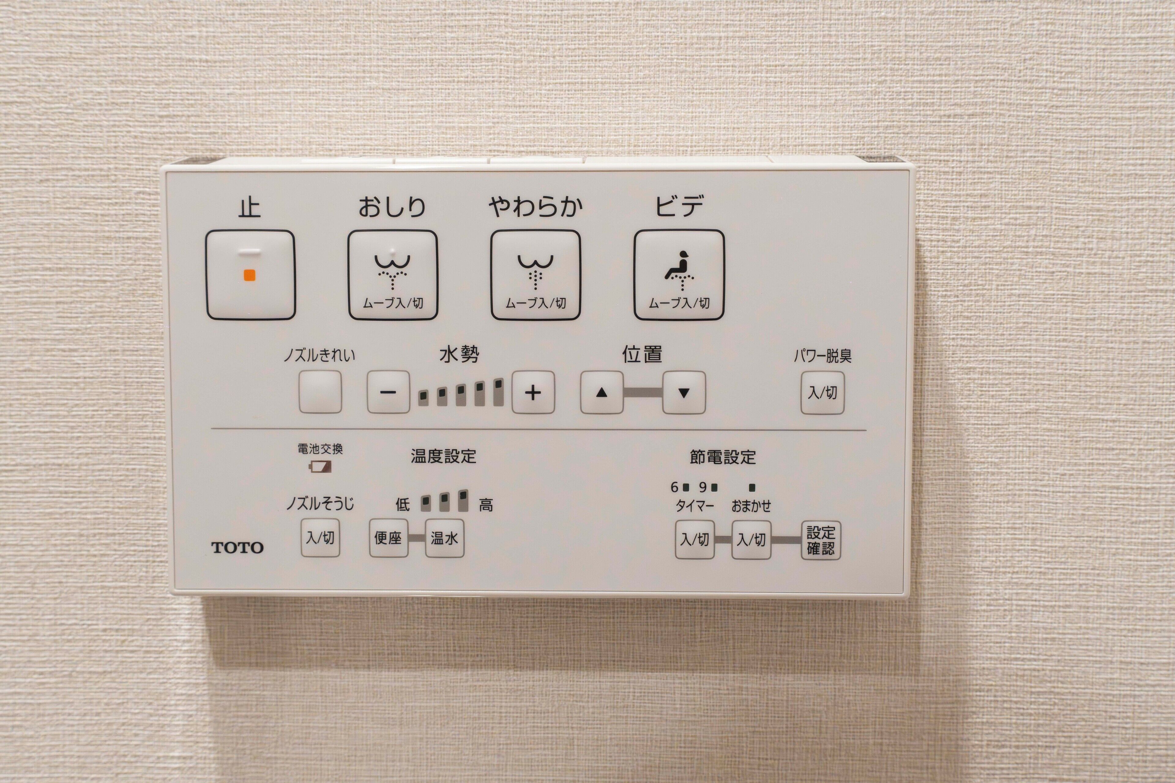 A control panel with Japanese labels, including buttons for stop, start, and water flow.