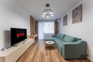 Apartamento luxo, sacada, vista para a montanha | Área de estar | Smart TV 125 cm com canais a cabo, Netflix, serviços de streaming