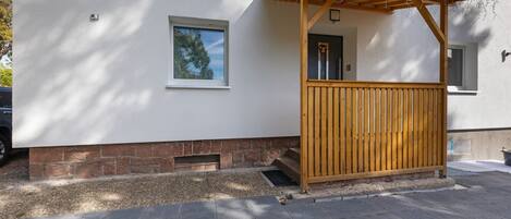 A building with a covered porch, a small window, and a door.