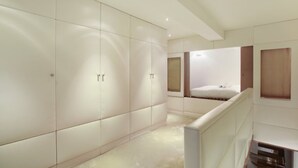A modern hotel room with a large wardrobe, a built-in bench, and a mirror. - A Modern and Unique Loft - Center of Paris (Paris)