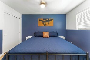 A bedroom with a bed, a wall-mounted painting, and a window with blinds. - The Rose 4 Apts|Pool|Gazebo|CentralPhx|Sleeps20 (Phoenix)