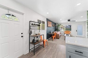 A modern kitchen with a dining area, white cabinetry, and a ceiling fan. - The Rose 4 Apts|Pool|Gazebo|CentralPhx|Sleeps20 (Phoenix)