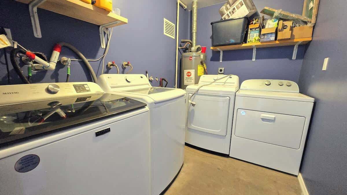 A laundry area with a washing machine, dryer, and stacked laundry baskets.