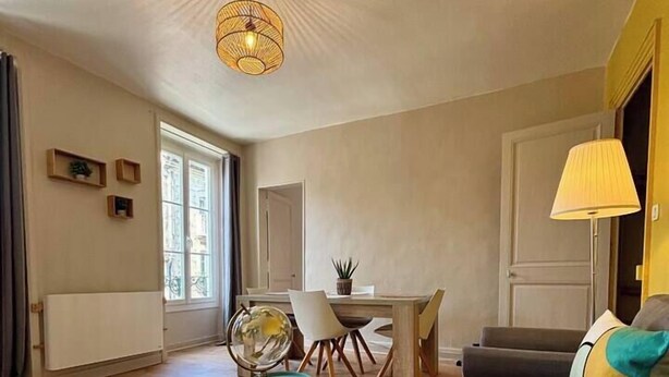 A spacious living room with a sofa, a dining table, and a globe. - Appartement Confort Laval Centre ! (Laval)
