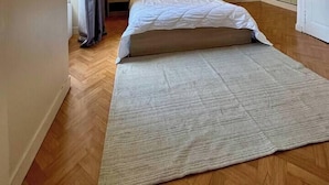 A bedroom with a bed, two bedside lamps, a window with curtains, and a wardrobe. - Appartement Confort Laval Centre ! (Laval)