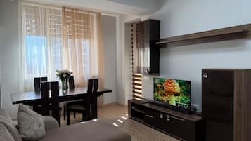 Apartamento Deluxe, 2 habitaciones, balcón, vistas al patio | Zona de estar | Smart TV de 50 pulgadas con canales por cable, un reproductor de DVD