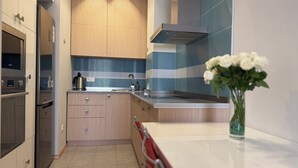 Una cocina moderna con armarios de madera, electrodomésticos de acero inoxidable y un salpicadero azul.