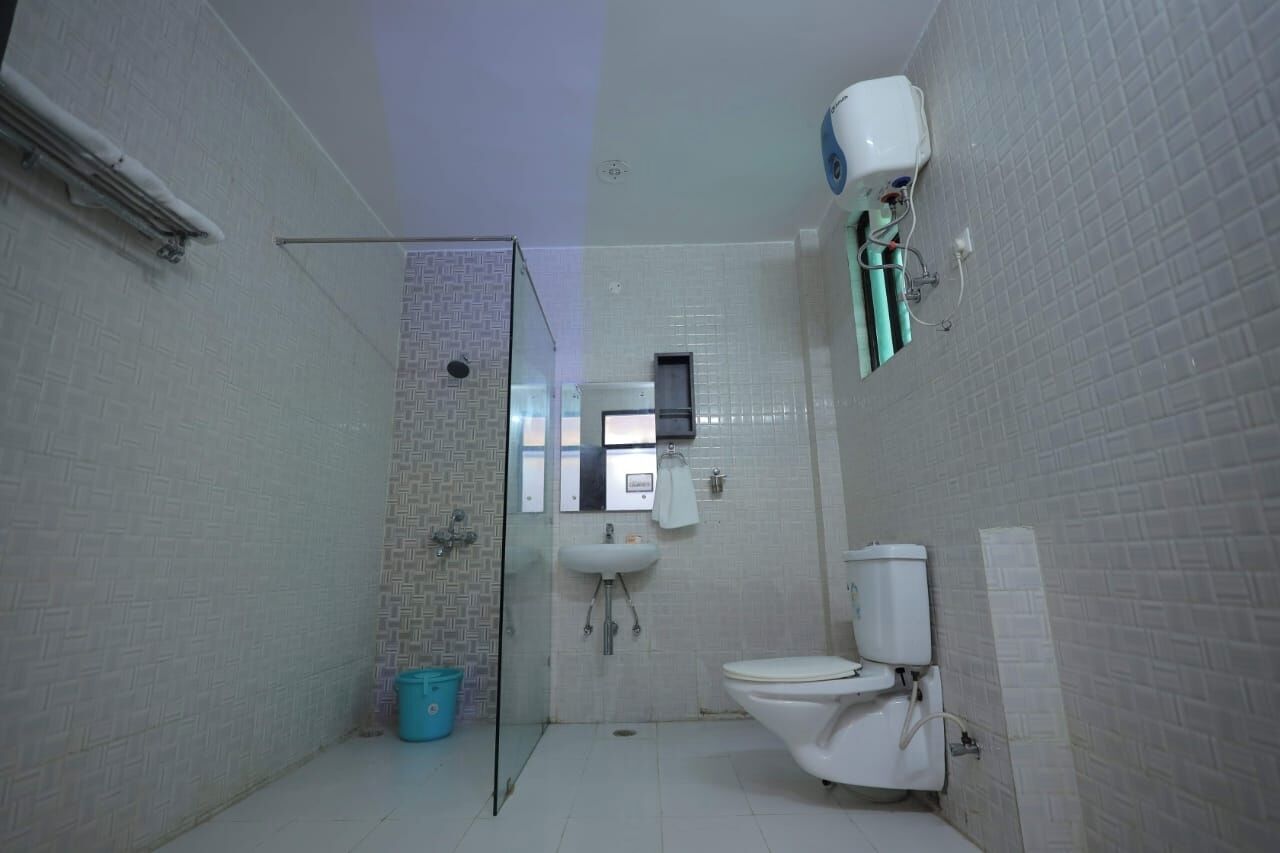 A compact bathroom with a glass shower enclosure, a white sink, and a toilet.