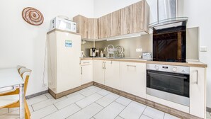 A modern kitchen with white cabinetry, a built-in oven, and a microwave.