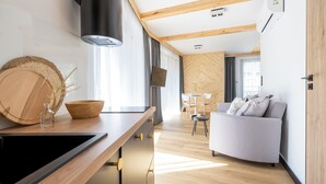 Une cuisine moderne dotée d’un plan de travail en bois, d’une cuisinière encastrée et d’un coin repas avec un canapé et une table.