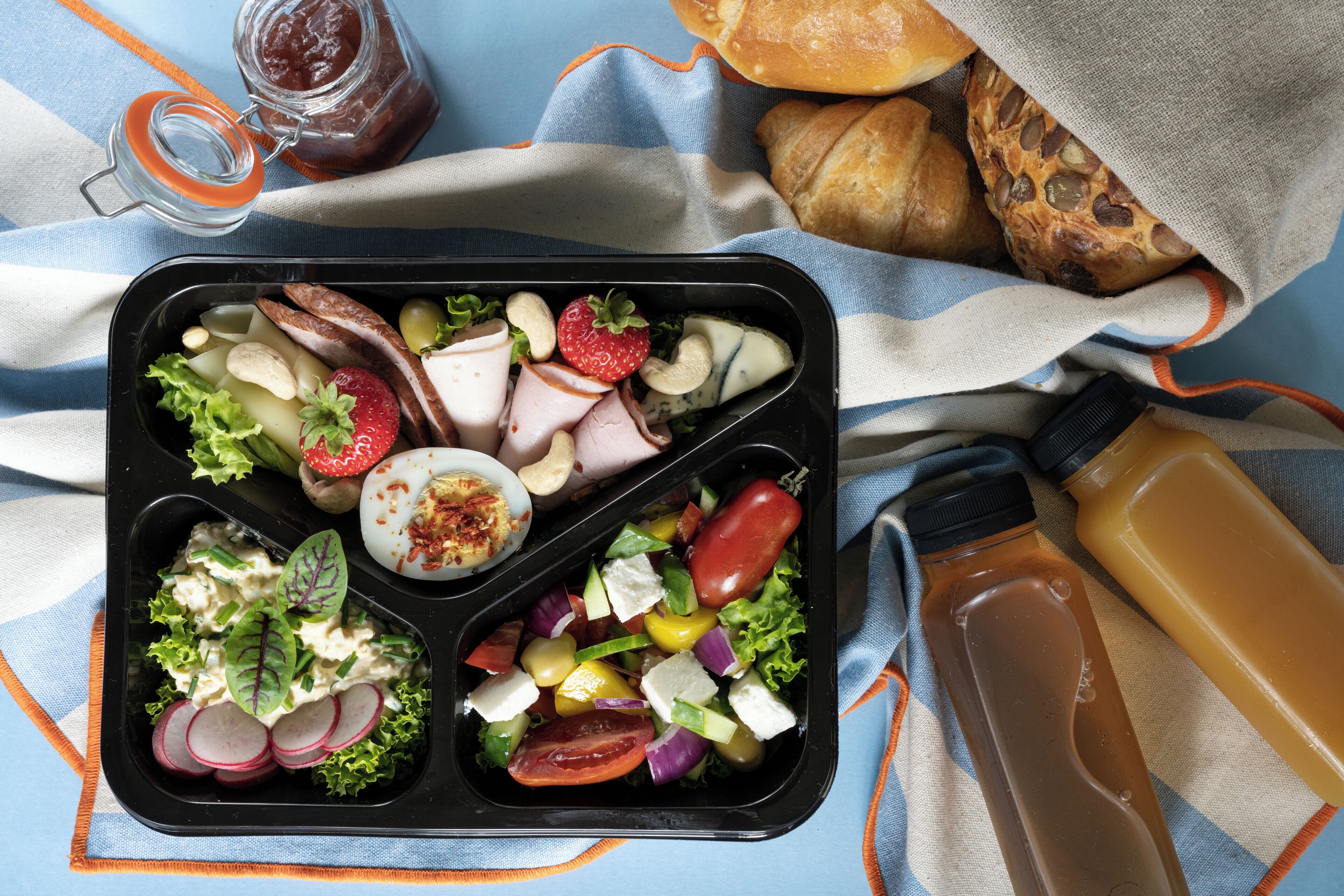 Een dienblad met verschillende soorten eten en twee flessen.