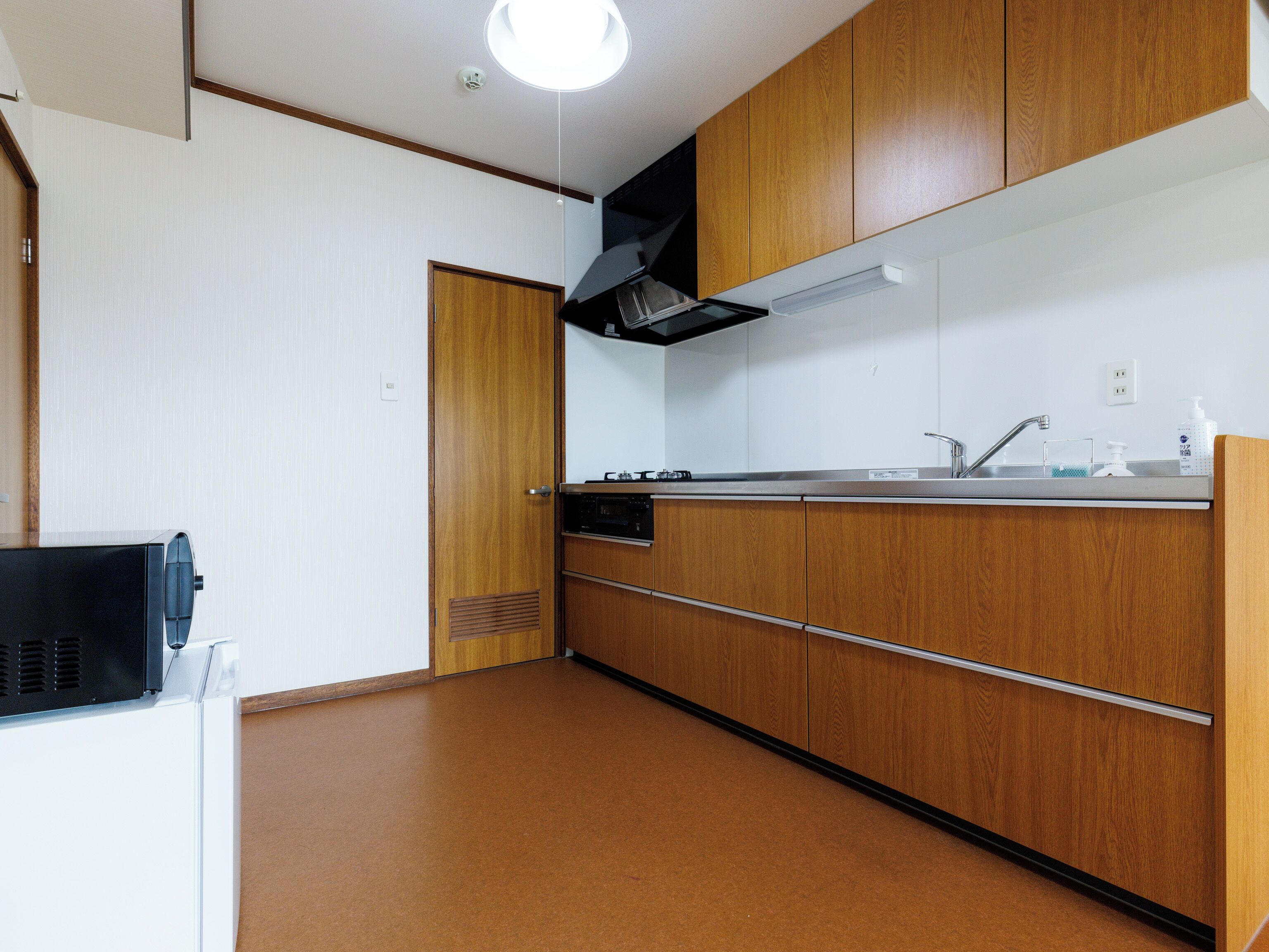 A kitchen with wooden cabinets, a stainless steel sink, and a built-in oven.