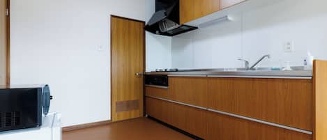 A kitchen with wooden cabinets, a stainless steel sink, and a built-in oven.