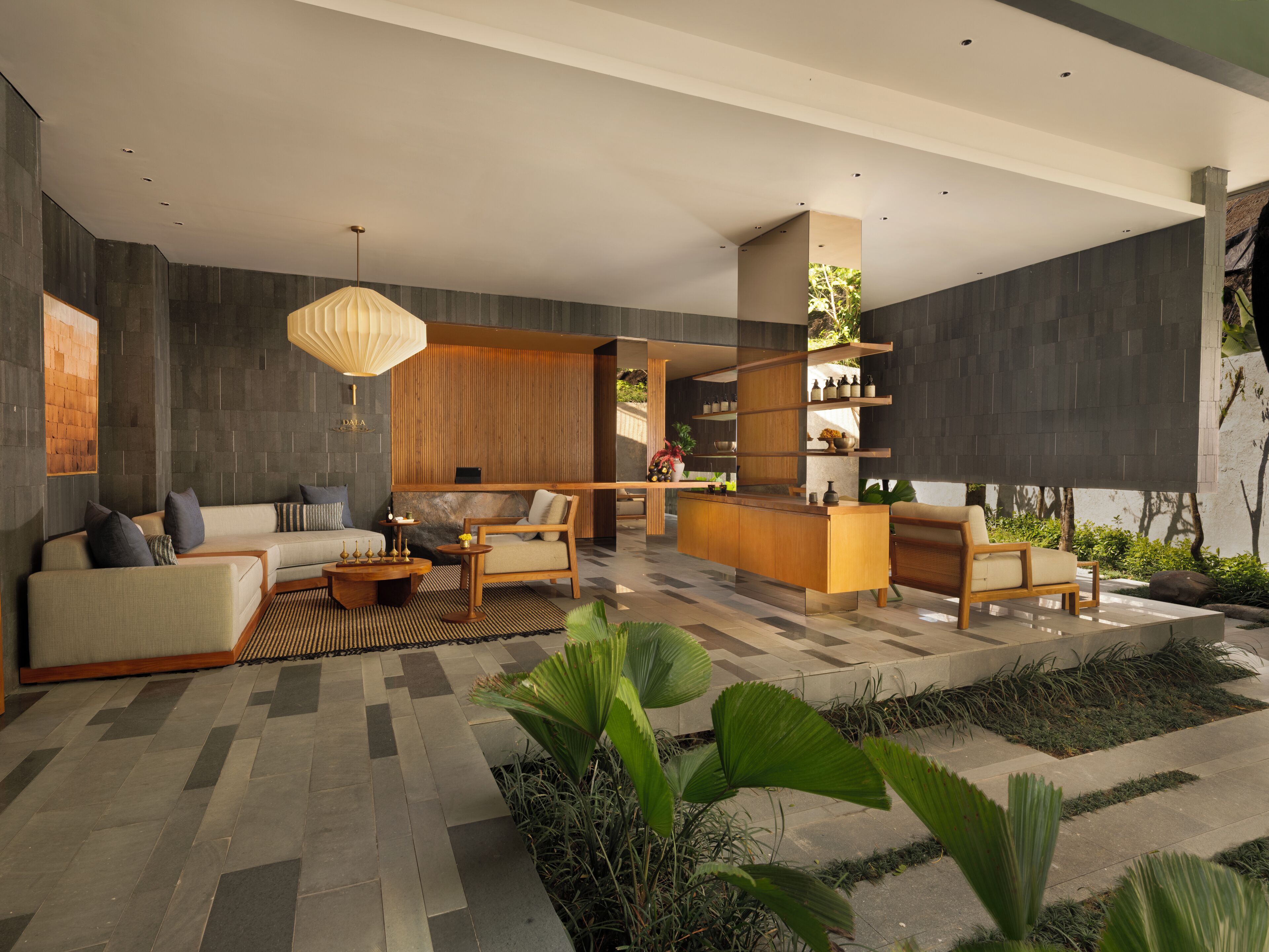 A modern living area with a sofa, chairs, a coffee table, and a bar area with shelves.