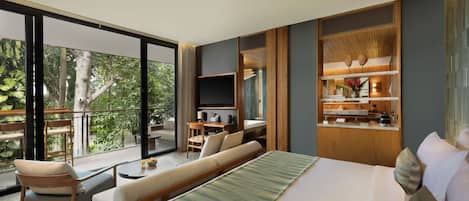 Una habitación de hotel moderna con una cama grande, un balcón con vistas a la vegetación, un escritorio pequeño y un televisor.