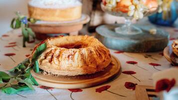 A table with a bundt cake, a fruit bowl, and a decorative item.