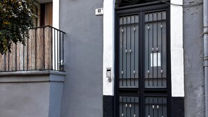 A building with a black and white facade, a black metal gate, and a small balcony. - Exclusive suite in the historic center of Catania, private entrance (Catania)