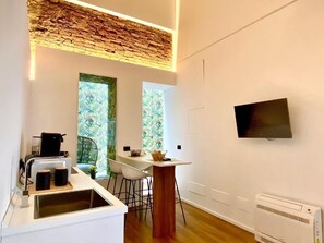 A modern kitchen with a built-in stove, a sink, and a dining area with a table and chairs. - Suite Mark – Exclusive Suite in the Heart of Catania's Historic Center (Catania)
