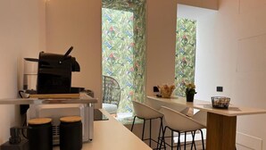 A modern kitchen with a coffee machine, two stools, and a small table. - Exclusive suite in the historic center of Catania, private entrance (Catania)