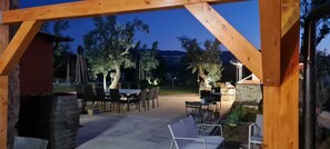 An outdoor patio area with a wooden pergola, tables, chairs, and a stone fireplace. - A village that preserves memory. A place to inhabit, not just to visit. (Cosenza)