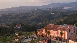 A hillside village with traditional buildings, a prominent red-roofed house, and a view of the surrounding landscape. - A village that preserves memory. A place to inhabit, not just to visit. (Cosenza)