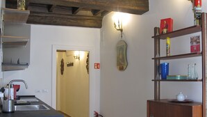 Una cocina con un lavamanos, un extintor y un comedor con una mesa para dos.