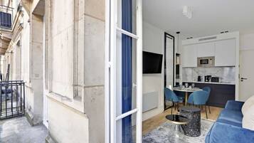 A modern apartment with a dining area, kitchen, and a balcony.