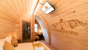 A wooden room with a bed, a shower, and a wall with a mountain painting. - Villa Yucca - B&B and Glamping (Torano Nuovo)
